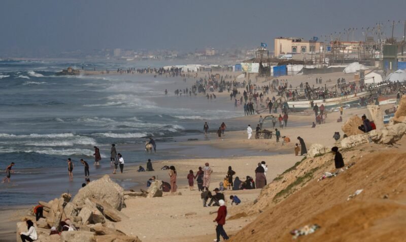 Palestinians gather on a beach in the hope of getting aid air-dropped over Gaza, amid the ongoing the conflict between Israel and Hamas, in the southern Gaza Strip February 27, 2024. REUTERS/Mohammed Salem