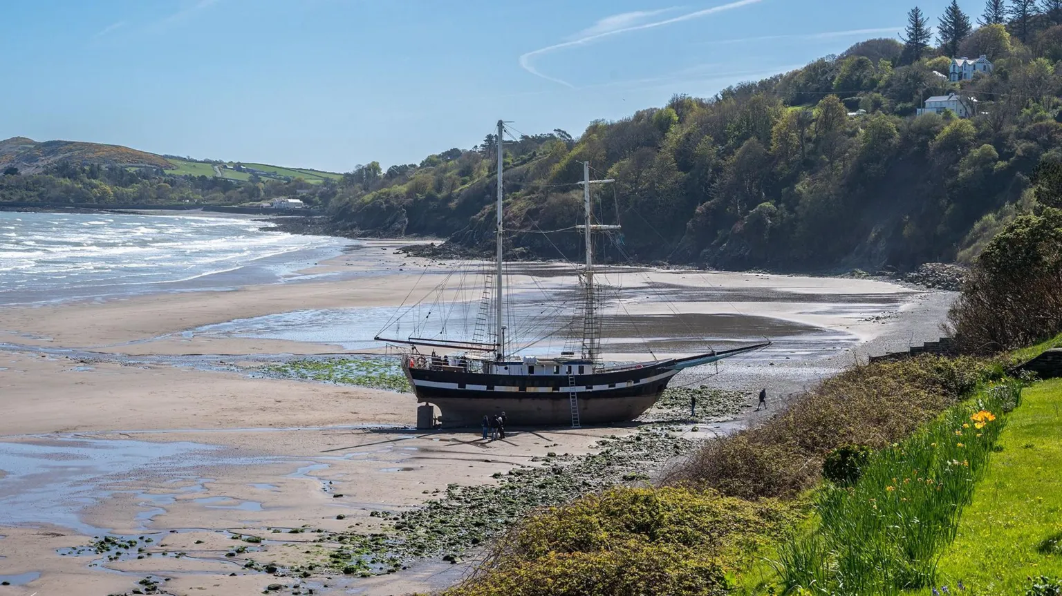Tall ship runs aground on beach in strong winds