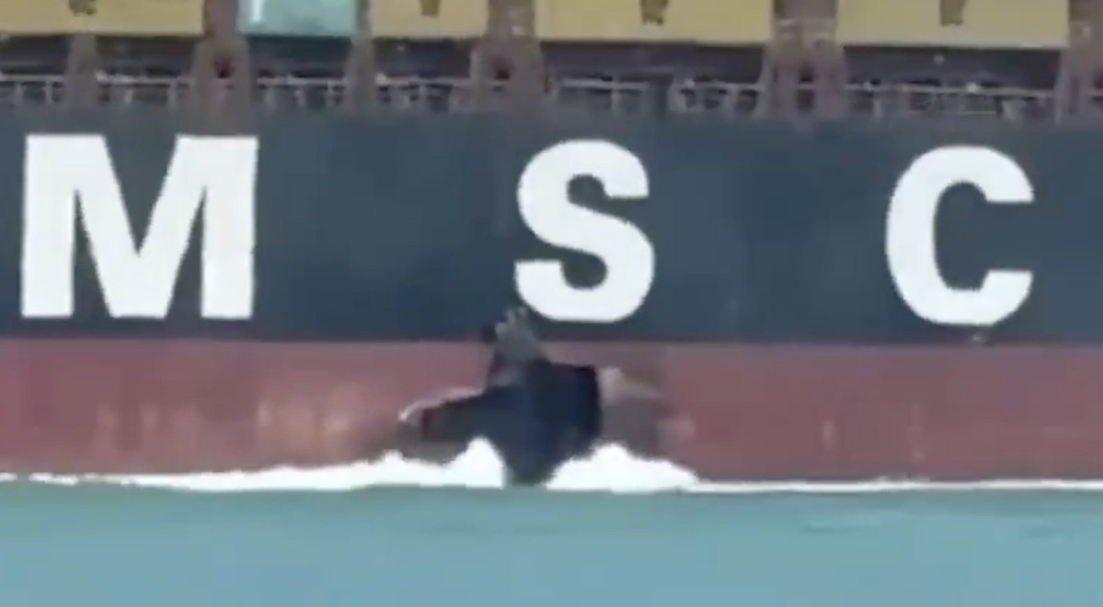 Screenshot from a circulating video showing hull damage above the waterline on the starboard side of the containership MSC Sariska V while underway in the Arabian Gulf.