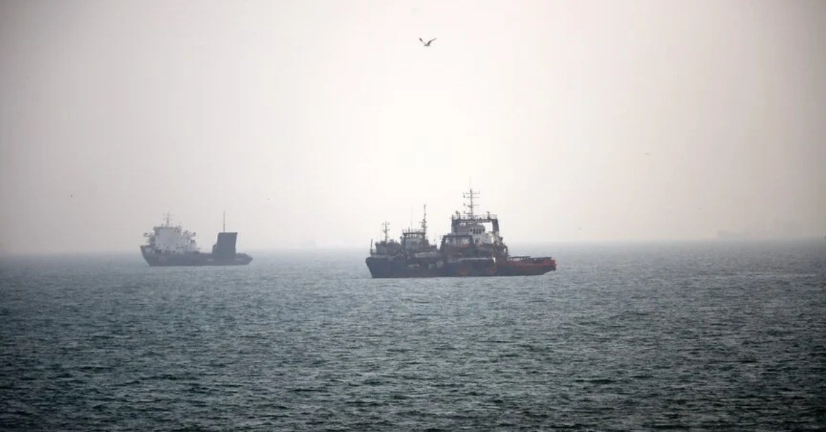 Merchant ships at anchor in hazy waters of the Strait of Hormuz