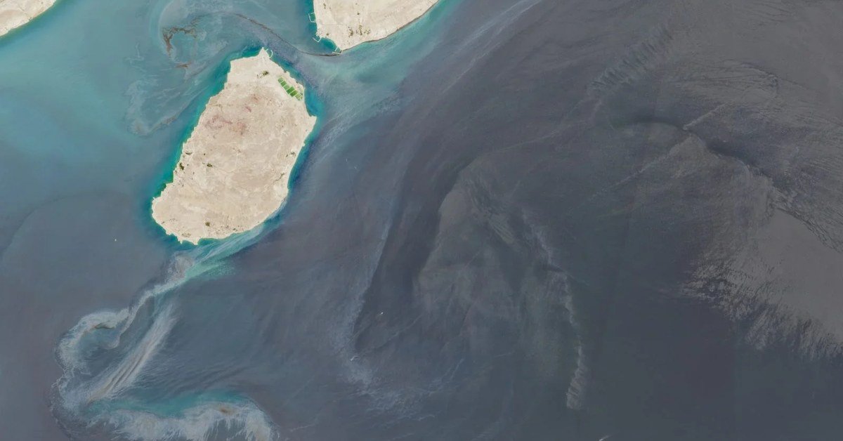 Aerial view of an oil slick spreading across the sea near the coast